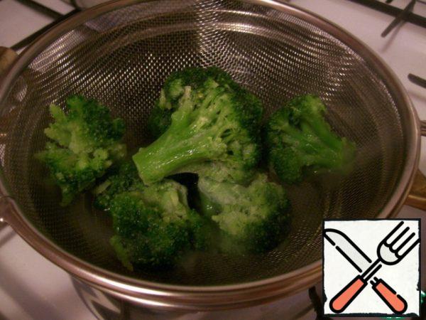 Insert the strainer on top of the pan with boiling water so that the water touches a little broccoli. Slightly moving the broccoli spoon, blanch it for no more than 3 minutes, so it remains bright green and crispy.
