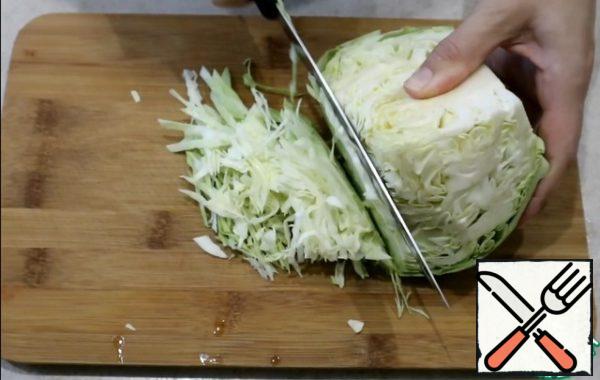 Chop the cabbage into thin and long strips. Put everything in a bowl.