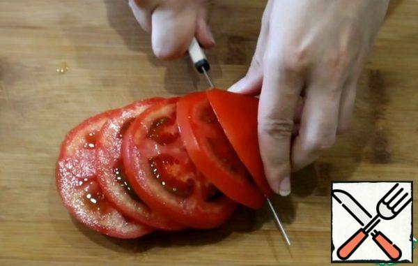 Wash the tomato and cut it into rings.