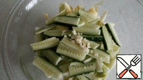 Add it cut into strips cucumber and garlic.