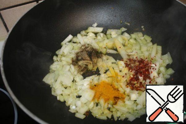 Cut the onion into small cubes.
Heat the oil and fry the onion with the addition of curry, red and black pepper.
Fry for about 5 minutes.
