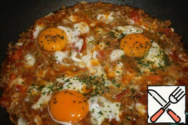 Stir one egg and pour evenly over the whole minced meat so that it grabs better.
And then carefully break the remaining eggs, try to distribute the protein over the surface too.
Close the lid and simmer on low heat until the eggs are ready.