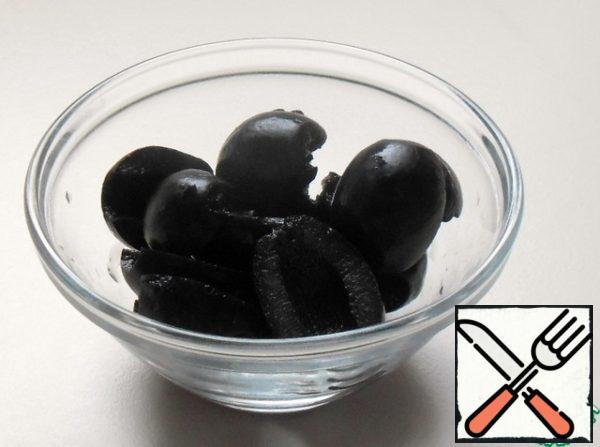 Cut the pitted olives into halves.
Wash the tomatoes, dry them and cut them into rings.
