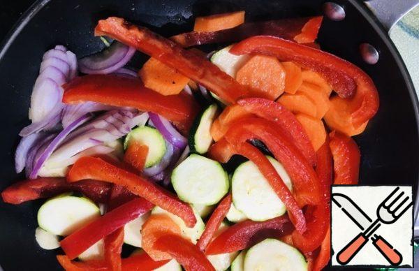 2 tablespoons vegetable oil pour into the pan, add the chopped garlic, pepper, carrots, zucchini and onions. Fry for about 10 minutes, stirring.