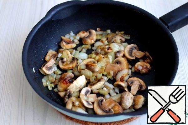 Chop the onion and mushrooms arbitrarily. Add 1 tablespoon of melted butter to the pan. Fry the onion and mushrooms until light golden brown.
