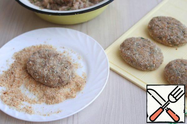 Knead the minced meat well. Cutlets are formed with wet hands. Sprinkle the cutlets with breadcrumbs.
