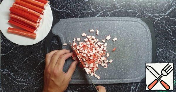 Take crab sticks and cut into small pieces.
