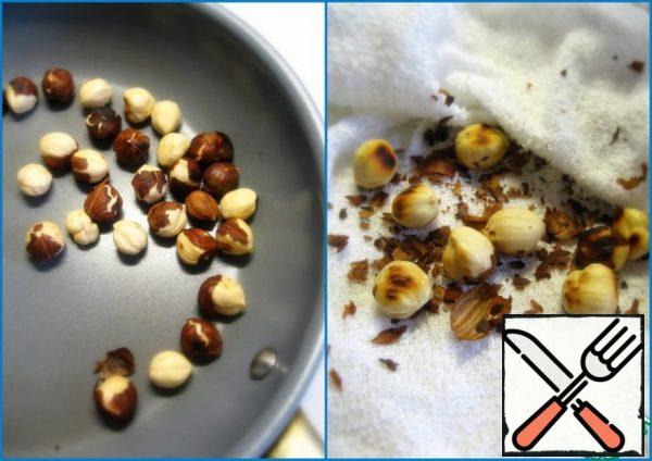 Fry the hazelnuts in a dry pan for 10 minutes. Allow to cool. RUB between wipes to get rid of husks.
