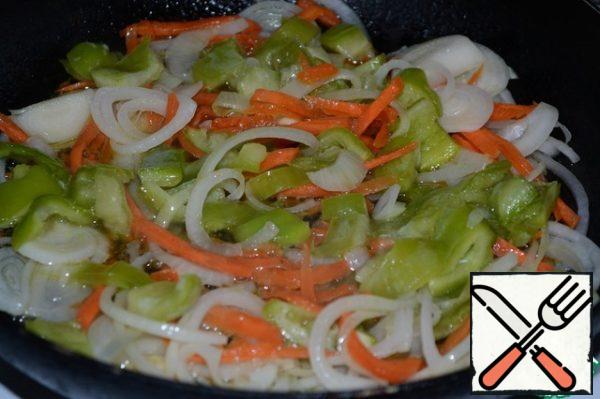 In the frying pan, where the shins were fried, put the onion and carrot, fry a little. Add the bell pepper and fry it for 3 minutes.
