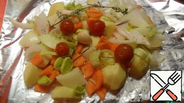 16 medium potatoes (4 servings) peel and cut into cubes. All the vegetables and season with salt and pepper. Prepare 4 sheets of foil such that fit and can be wrapped vegetables and veal. Grease each with butter. Spread mixed vegetables: potatoes, onions, leeks, tomatoes, carrots, put on top of a clove of garlic, a sprig of rosemary and thyme.