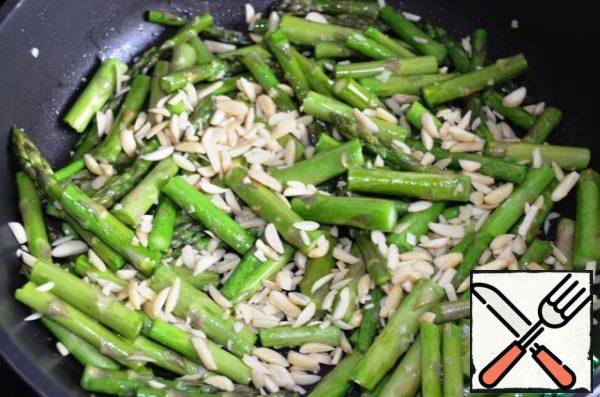 Add the nuts to the asparagus and fry for another 3-4 minutes (under the lid).