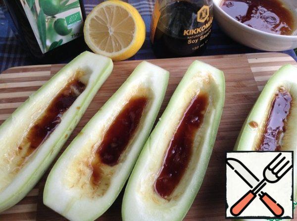 Young zucchini in half lengthwise, remove the pulp with a spoon,
to form a boat.
Preparing sauce:
mix 3 tsp soy sauce, 1 tsp olive oil and 1 tsp lemon juice. It's the perfect ratio for me.
You try to your taste may need something to adjust.
Pour the zucchini sauce and leave to marinate.