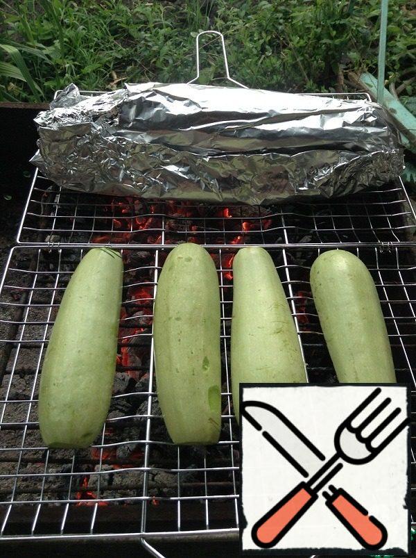 Meanwhile, lay out the marinated zucchini on the grill notch down.
Just note that the heat should not be very strong, move some of the coals to the side, zucchini are very tender and can burn.