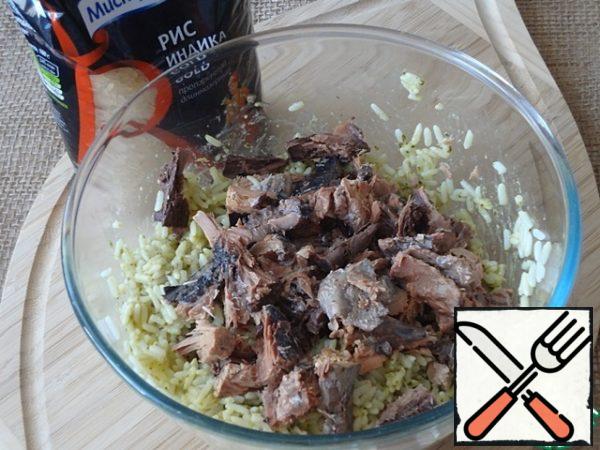 Drain the liquid from the tuna can. Divide the fish into large pieces. Put in a salad bowl with rice.