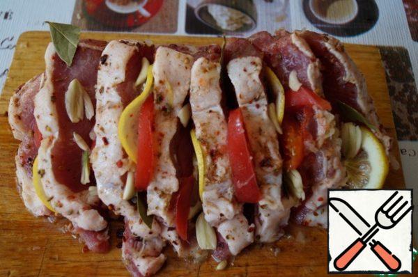 Rub the meat with seasoning (it is better for grilling), season with salt, sprinkle generously with lemon juice. Insert lemon slices, tomatoes, crushed garlic cloves, bay leaf into the cuts, sprinkle with coriander. Let it marinate for about 40 minutes -1 hour.
