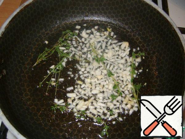 In hot vegetable oil, fry the chopped garlic and a few sprigs of thyme for 1-2 minutes. Get sprigs of thyme.