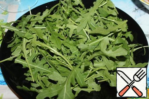 On a plate (or salad bowl) put washed and dried arugula.