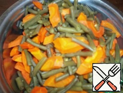 String beans and carrots coarsely cut and boil together until half-cooked, 10 minutes, in one saucepan. Put it in a colander.