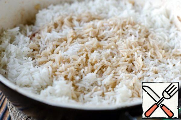 Put the boiled rice in a frying pan, pour the remaining soy sauce and add sugar. Mix everything well so that the rice is evenly distributed and absorbs the sauce, reduce the heat and cook for another 2 minutes.