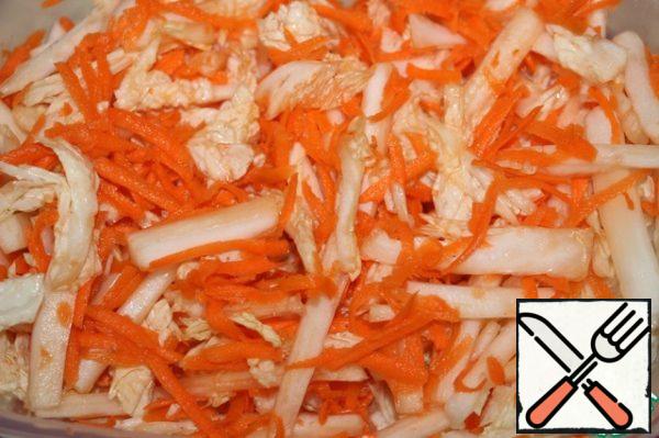 Wash the Peking cabbage and cut it into thin strips. Peel the carrots and grate them on a coarse grater. Put the cabbage and carrots in a bowl, add a little salt and mash with your hands.
