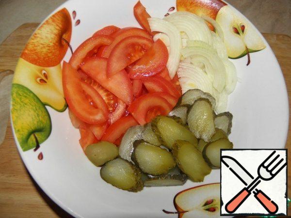 Cut cucumbers, tomatoes and onions.