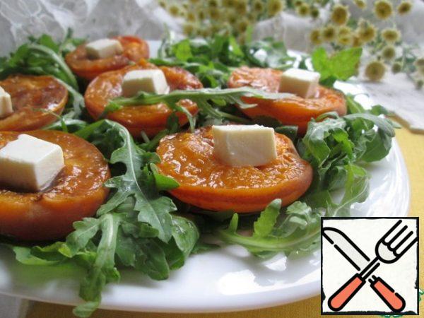 Put on a plate arugula, large-tear hands, top-halves of apricots cut upwards. In each place a piece of feta and, and, then, pour the sauce.