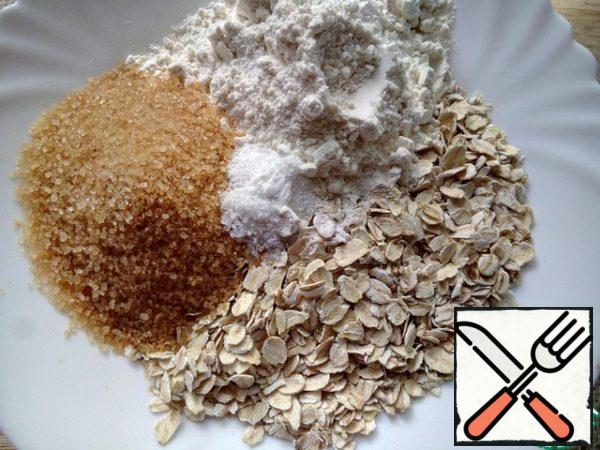 Mix the oatmeal, flour, sugar, baking soda and salt in a bowl.
Soda will make crumble even more crumbly and tender, but for the preparation of the traditional version of crumble to use it optional.