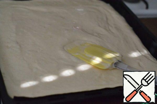 Cover the baking tray 35x45 with baking paper or Teflon sheet.
Pour out the dough and smooth with a spatula.