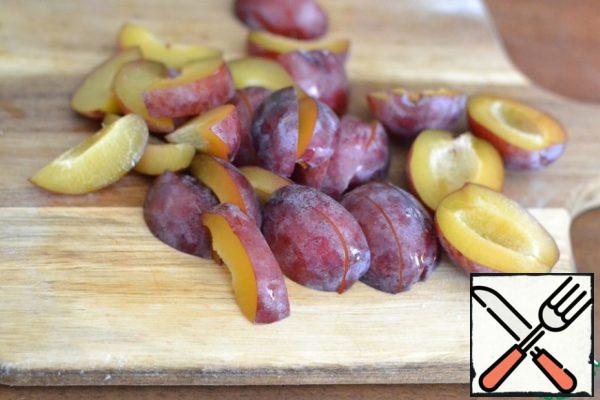 Cut the plums into quarters.
