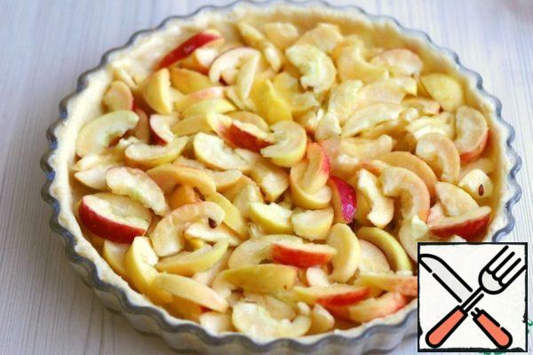 Form for baking grease with oil, sprinkle with breadcrumbs. Put the dough in small pieces, spread it evenly over the entire form. Form bumpers.Apples cut into slices/pieces. I want to note that the recipe used sweet and sour apples soft varieties.