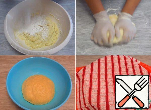 As soon as all the flour is moistened, pour in small portions of the remaining 100 g of flour. When the dough becomes difficult to stir, transfer it to the work surface and start kneading with your hands. The finished dough should be soft and slightly stick to your hands. I put it in a clean, greased bowl and cover it with cling film and a towel.
