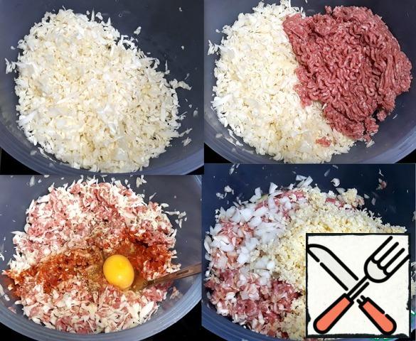 Crushed cabbage poured into a deep
a bowl and put the mixed mince. Stirred,
broke the egg and poured salt, pepper, dried
herbage. Added to the minced chopped onions, garlic
and shredded cheese. The contents of the bowl are good
stirred. Mince is ready.