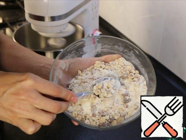 While the whites are whipped, mix the nuts, flour, sugar (180 g), vanilla sugar. Mix it.
