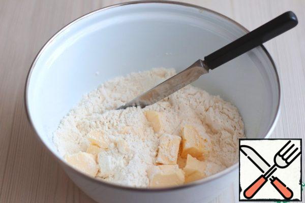 In a bowl add flour (3 cups), add baking powder (1 teaspoon), add 180 gr. cold butter. Chop the flour and butter into small crumbs with a knife.