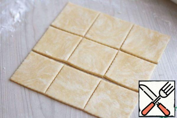 Remove the dough from the refrigerator, divided into two parts, each part roll out to a thickness of approximately 2 - 3 mm. With a knife or knife - roller to cut the crust into squares 7 - 8 cm In the middle of each square put the stuffing of raisins and nuts. Form triangles.