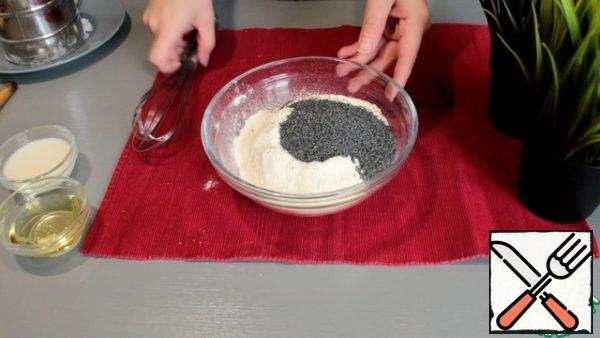 Next, sift the flour and baking powder into a bowl, add the poppy seeds there. Mix well.