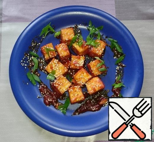 Put the tofu on a plate, sprinkle with sesame seeds and green onions.
This is done.
Treat.