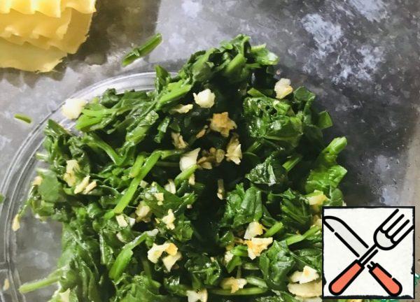 Wash the spinach, finely chop the garlic, put it in a dry frying pan, simmer until the spinach is soft, so that the water evaporates.
