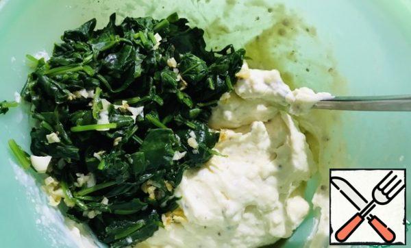 Add soft spinach to the cottage cheese. Stir with a spoon.
