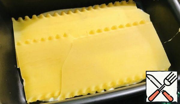 Lay out two sheets of lasagna.
