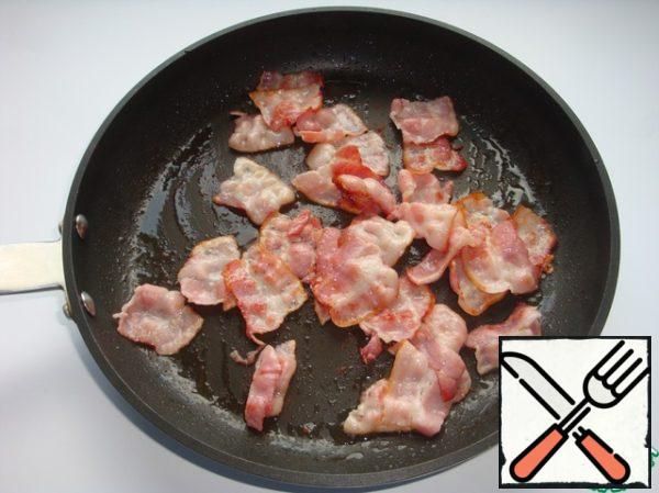 Mix the vegetable mixture with pasta, bacon and seeds, season with sauce and crumble the cheese there.