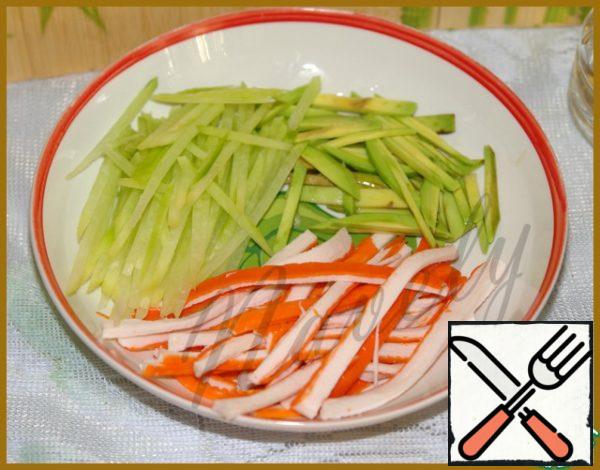 Peel the radish and avocado and cut into strips on a grater for Korean carrots, immediately sprinkle the avocado with lemon juice, so as not to darken.
Crab sticks are also cut lengthwise, thin strips. Stir.