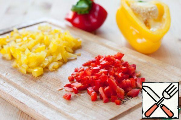 All the ingredients for the salad should be cut into pieces of approximately the same size.
Cut the halves of red and yellow bell peppers into small cubes.
