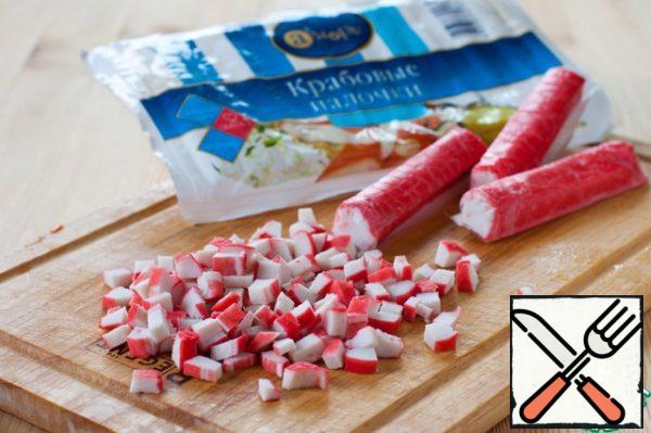 Defrost crab sticks and chop them finely.