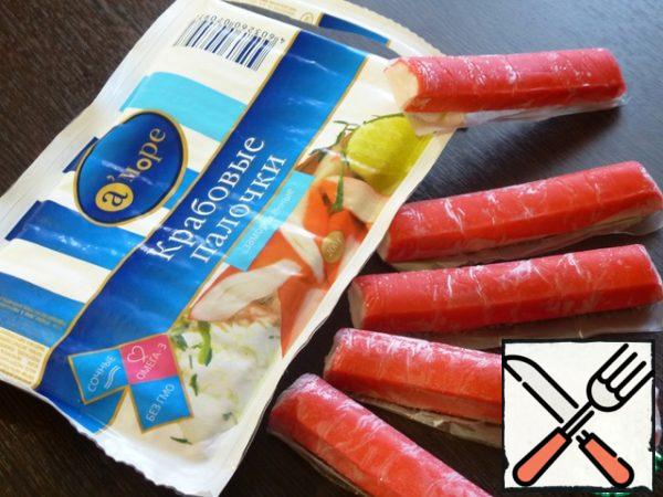 The first step is to defrost the crab sticks and remove the wrapper.