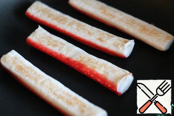 If you are the lucky owner of a frying pan, the next step is better to do on it. But I don't have one, so I warmed up a regular frying pan, greased it with a little oil and laid out the prepared crab sticks. Fry them on both sides until Golden brown.