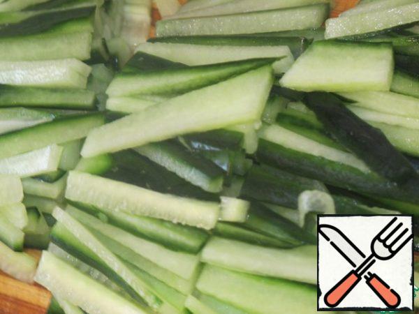 Cut the cucumber into thin strips 4 x 0.5 cm .
