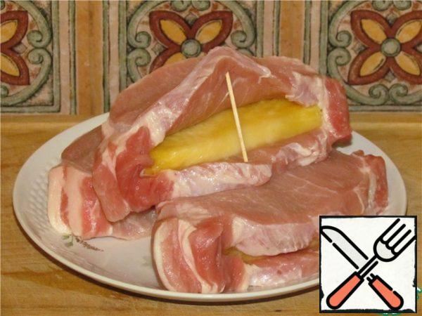 Make an incision on the side of each piece of meat to make a pocket, rub with salt and pepper. Enclose half rings of pineapple.
