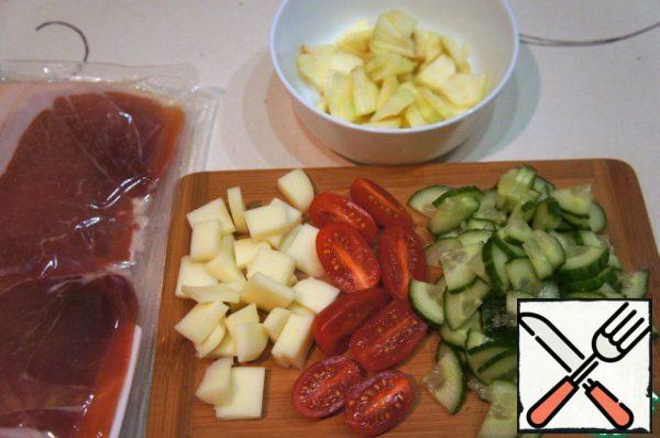 Cucumber and apple cut into thin triangular slices, tomatoes cut in half, suluguni cut into small cubes.
