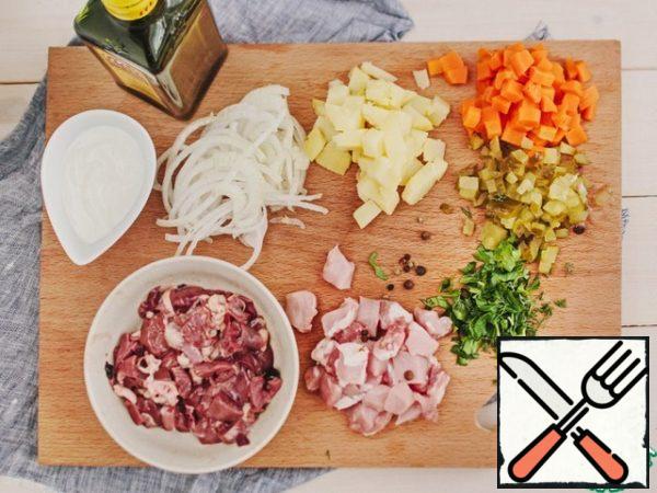 Peel the vegetables, cut into cubes, cut the onion into half rings. Most of the cucumbers are also cut into cubes. Cut chicken hearts into halves, liver and pork into small pieces.
